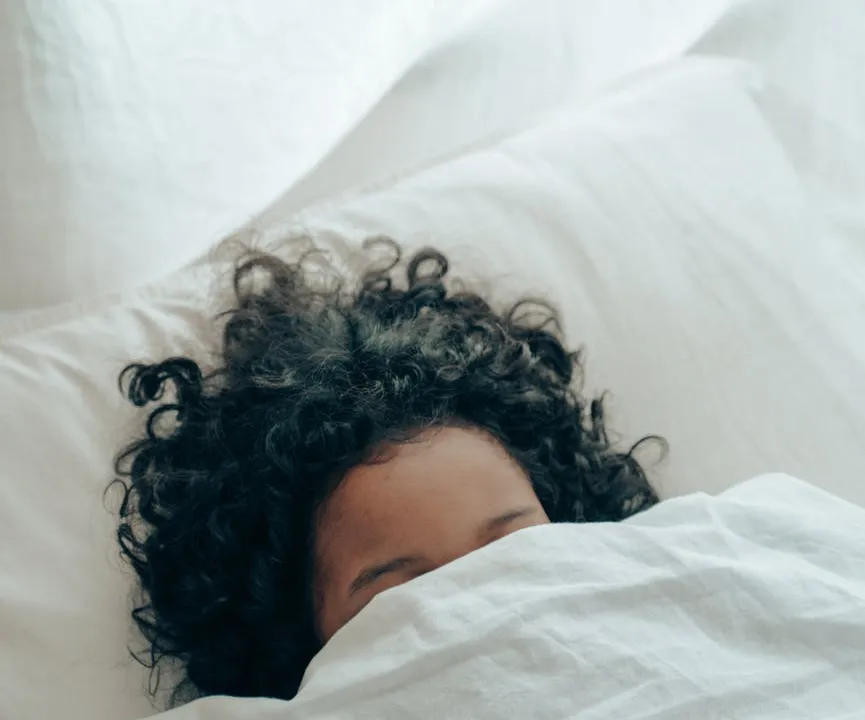 unrecognizable person sleeping under blanket